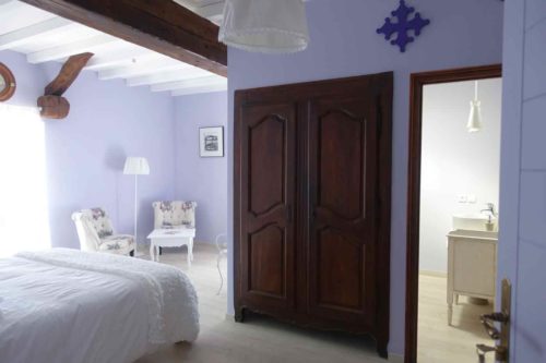 Vue de la chambre Occitane avec lit, 2 fauteuils, et croix occitane